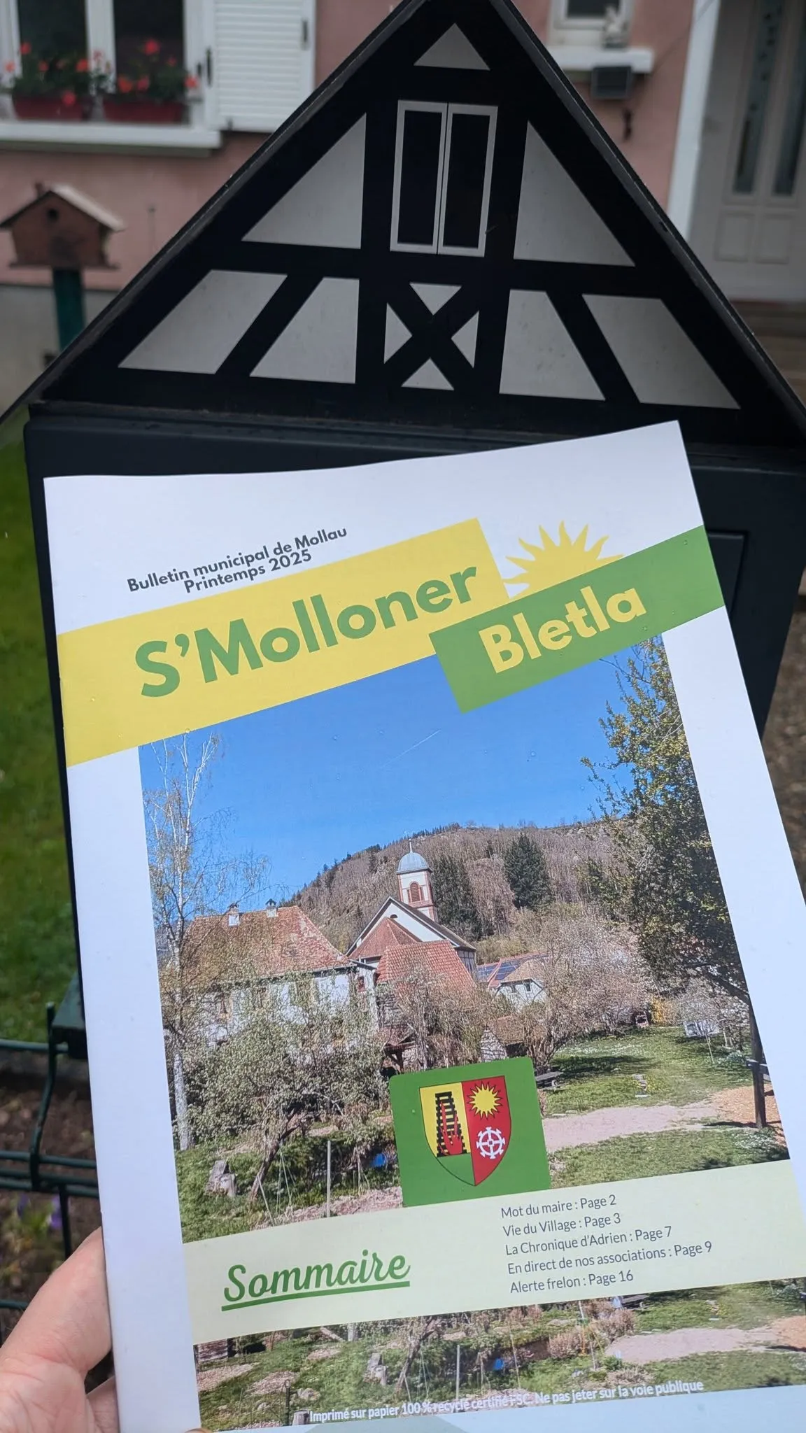 Un bulletin municipal moderne posé sur un bureau de mairie